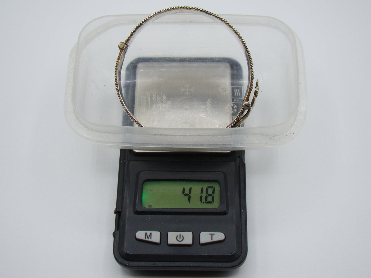 Silver hinged bangle on a digital scale displaying 41.8 grams.