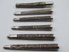 Reverse view of six silver filigree mouthpieces with open tubular ends visible