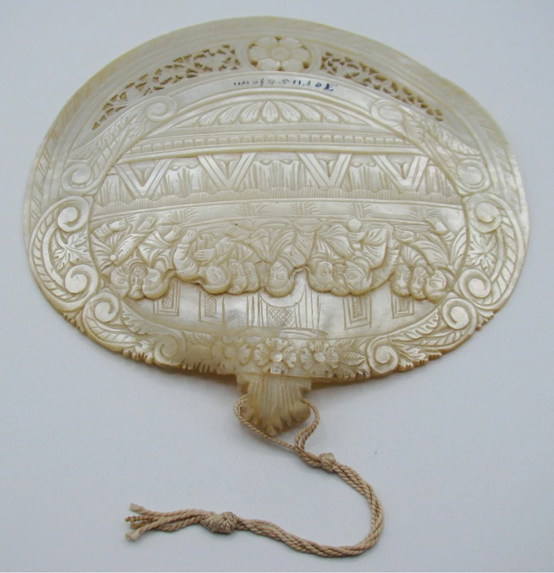 Front view of mother-of-pearl Last Supper shell with Jerusalem inscription, floral openwork and attached cord