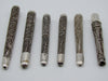 Angled view of the open ends and intricate filigree on six antique silver mouthpieces