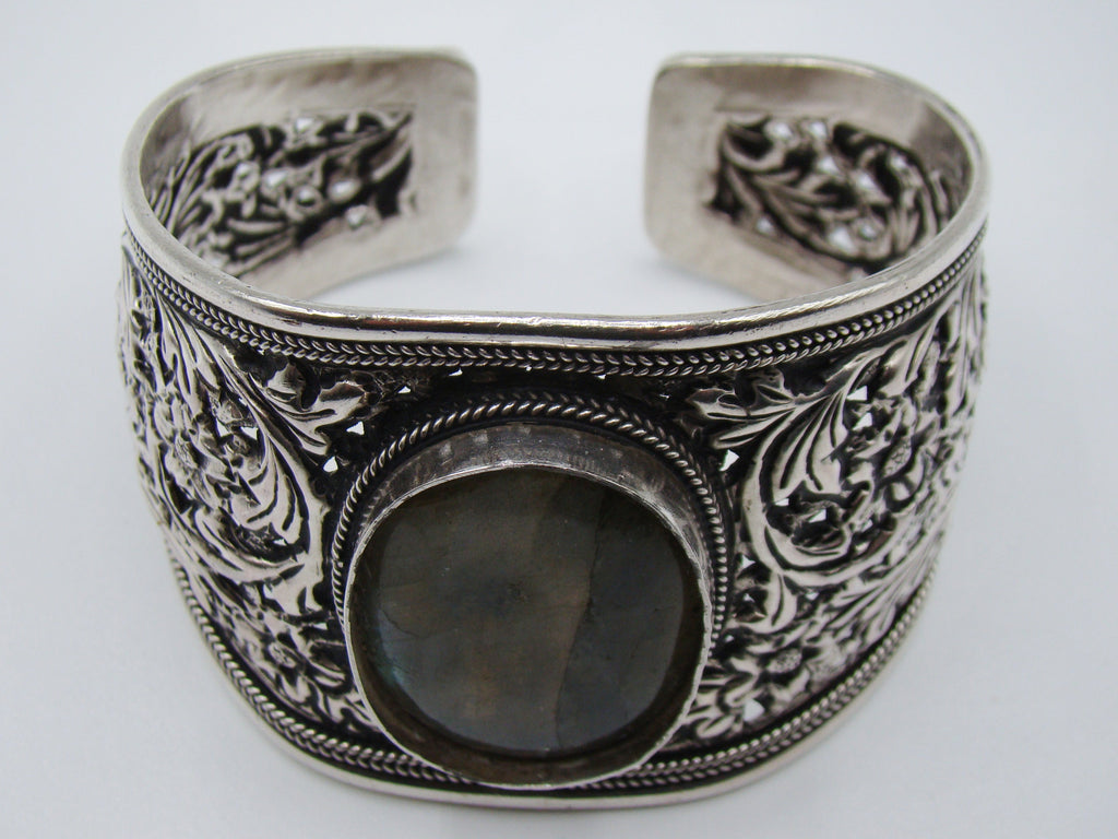Silver floral cuff bracelet on a digital scale displaying total weight of 54.7 grams