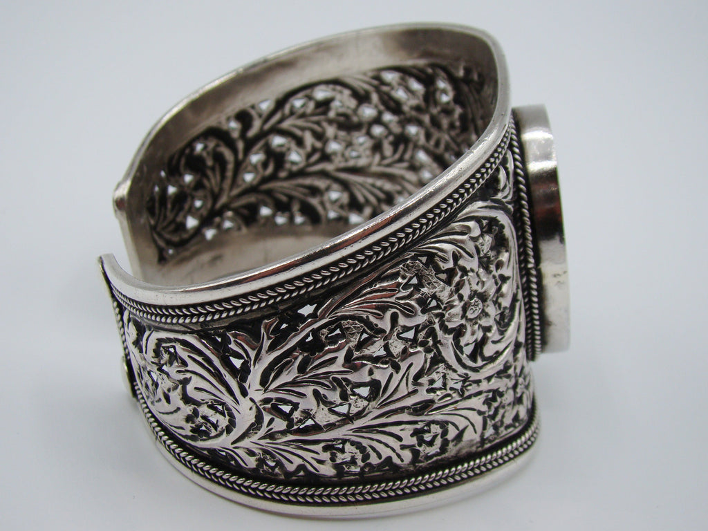 Front view of 925 silver cuff bracelet with oval centrepiece, floral openwork and rope-like borders