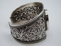 Front view of 925 silver cuff bracelet with oval centrepiece, floral openwork and rope-like borders