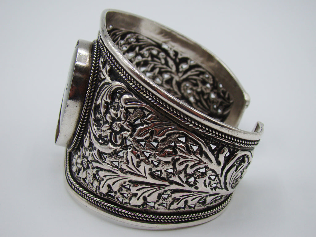 Interior view of silver cuff showing the 925 stamp, openwork and reverse of the centre setting