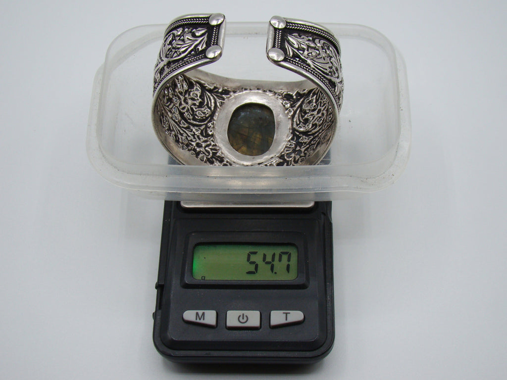 Rear view of open-backed silver cuff showing finished terminals and interior surface wear