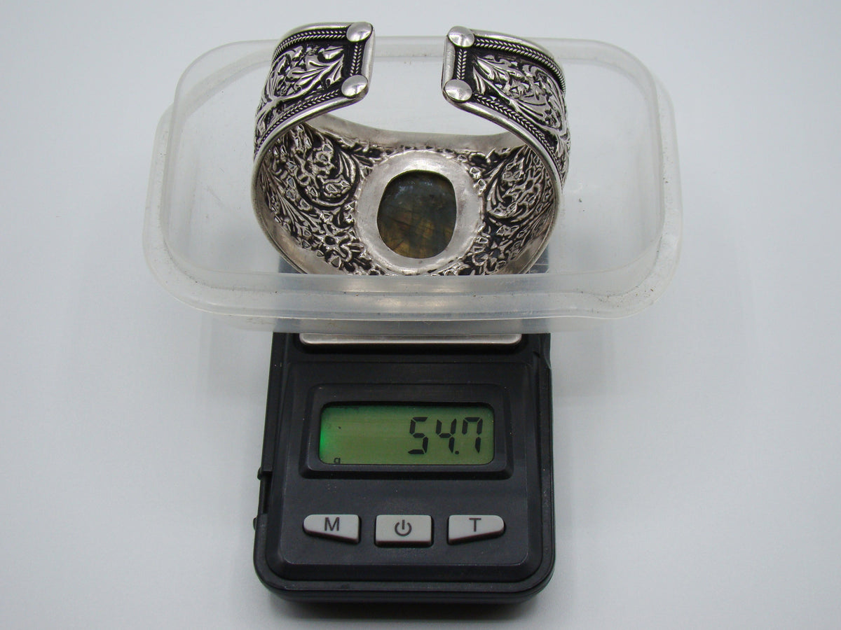 Rear view of open-backed silver cuff showing finished terminals and interior surface wear