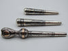 Side view of the three-piece antique silver mouthpiece lot