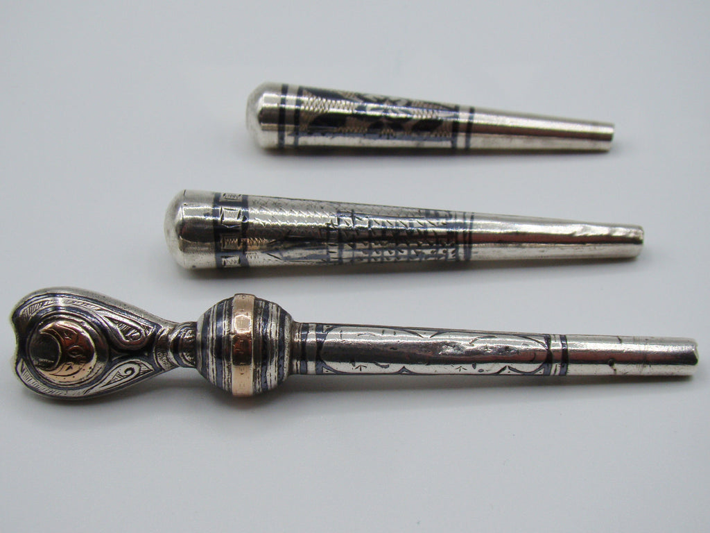 Side view of the three-piece antique silver mouthpiece lot