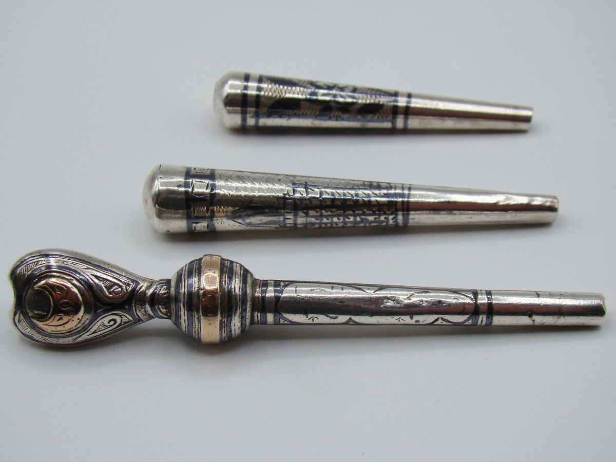 Side view of the three-piece antique silver mouthpiece lot
