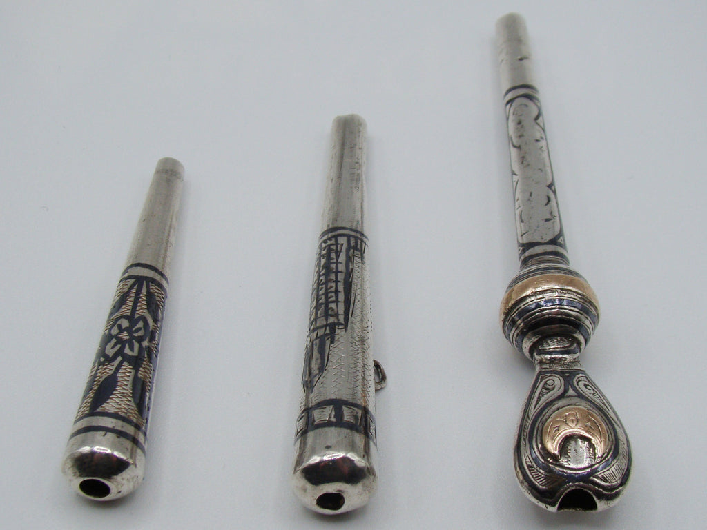 End view showing openings and contrasting decoration on three silver mouthpieces