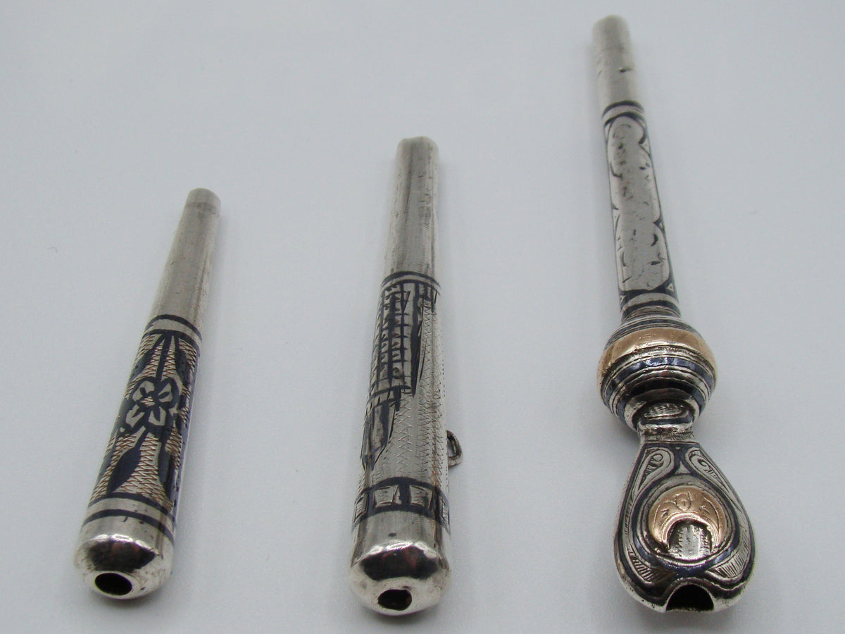 End view showing openings and contrasting decoration on three silver mouthpieces