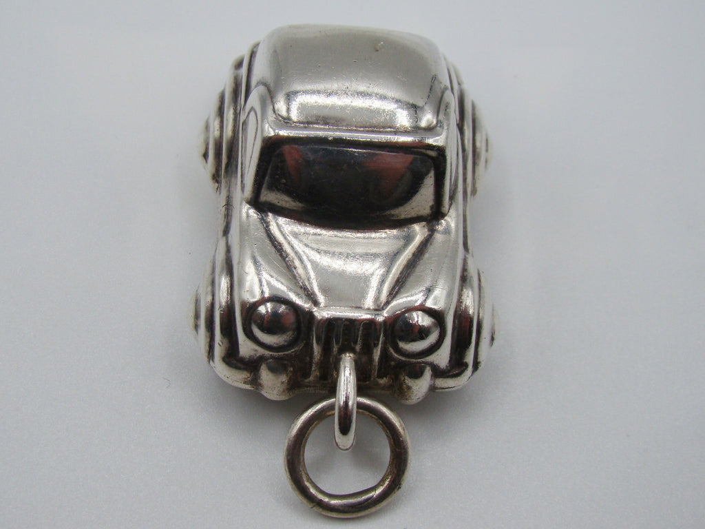 Front view of silver miniature car pendant showing grille and headlights