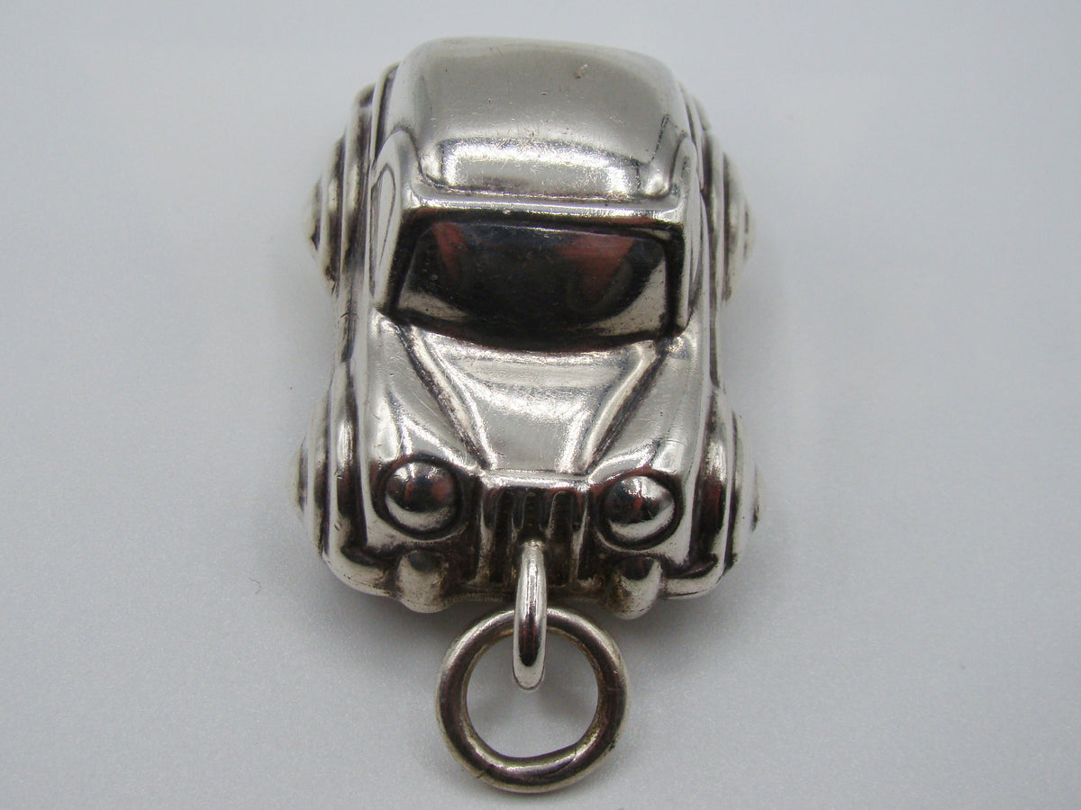 Front view of silver miniature car pendant showing grille and headlights