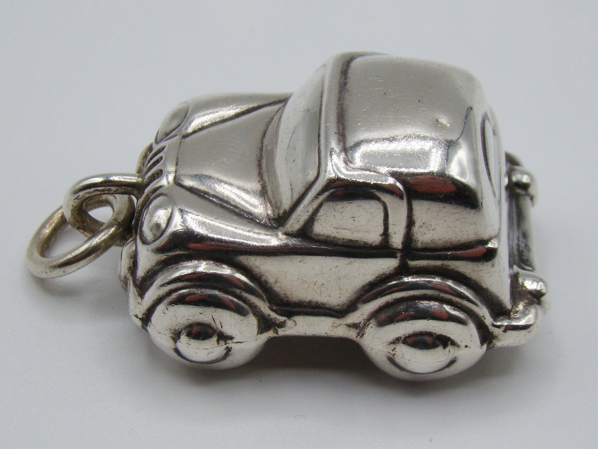 Opposite side of silver miniature car showing windows and wheel arches