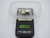 Silver miniature car on a scale displaying 21.5 grams