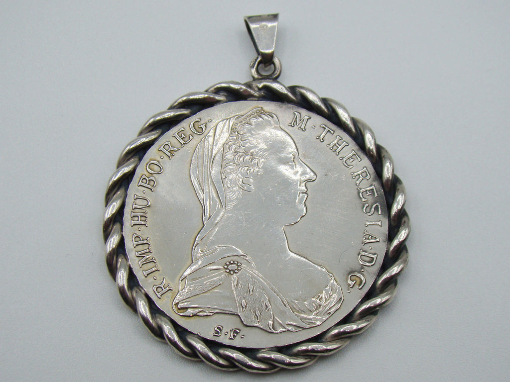 Maria Theresa silver coin pendant with twisted rope-style frame and suspension bail