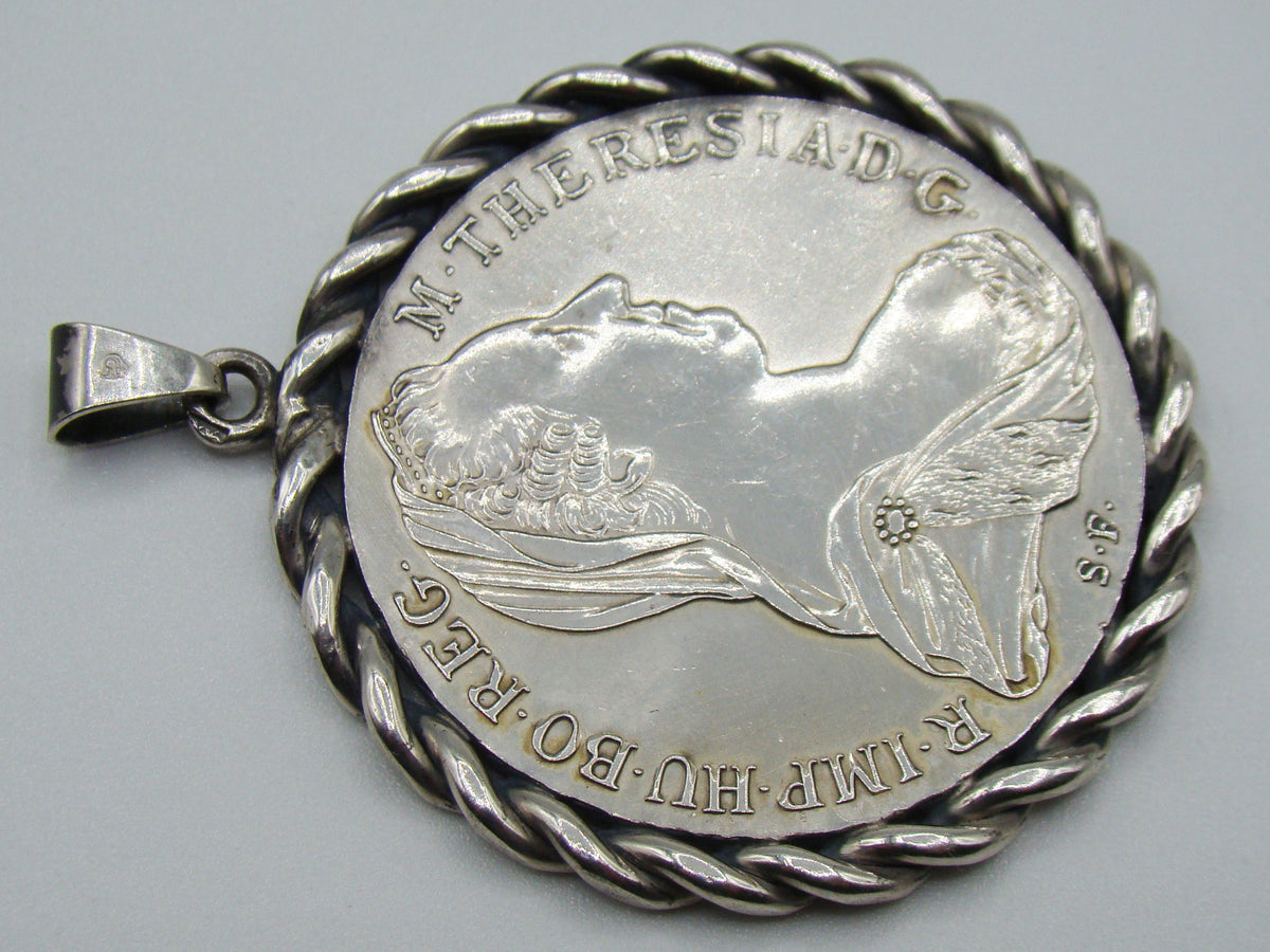 Angled portrait-side view of Maria Theresa silver coin pendant