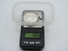 Mounted silver coin pendant on scale displaying total weight of 38.5 grams