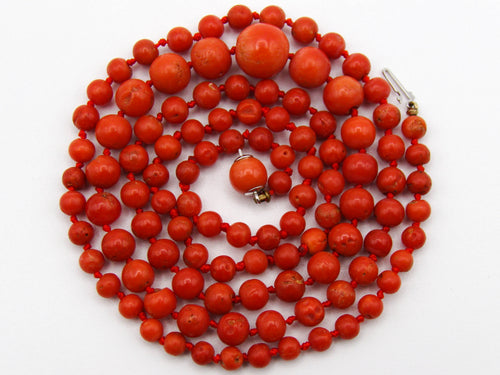 20th-century Mediterranean red coral necklace arranged in a coil, with graduated knotted beads and an 835 silver clasp with a red centre