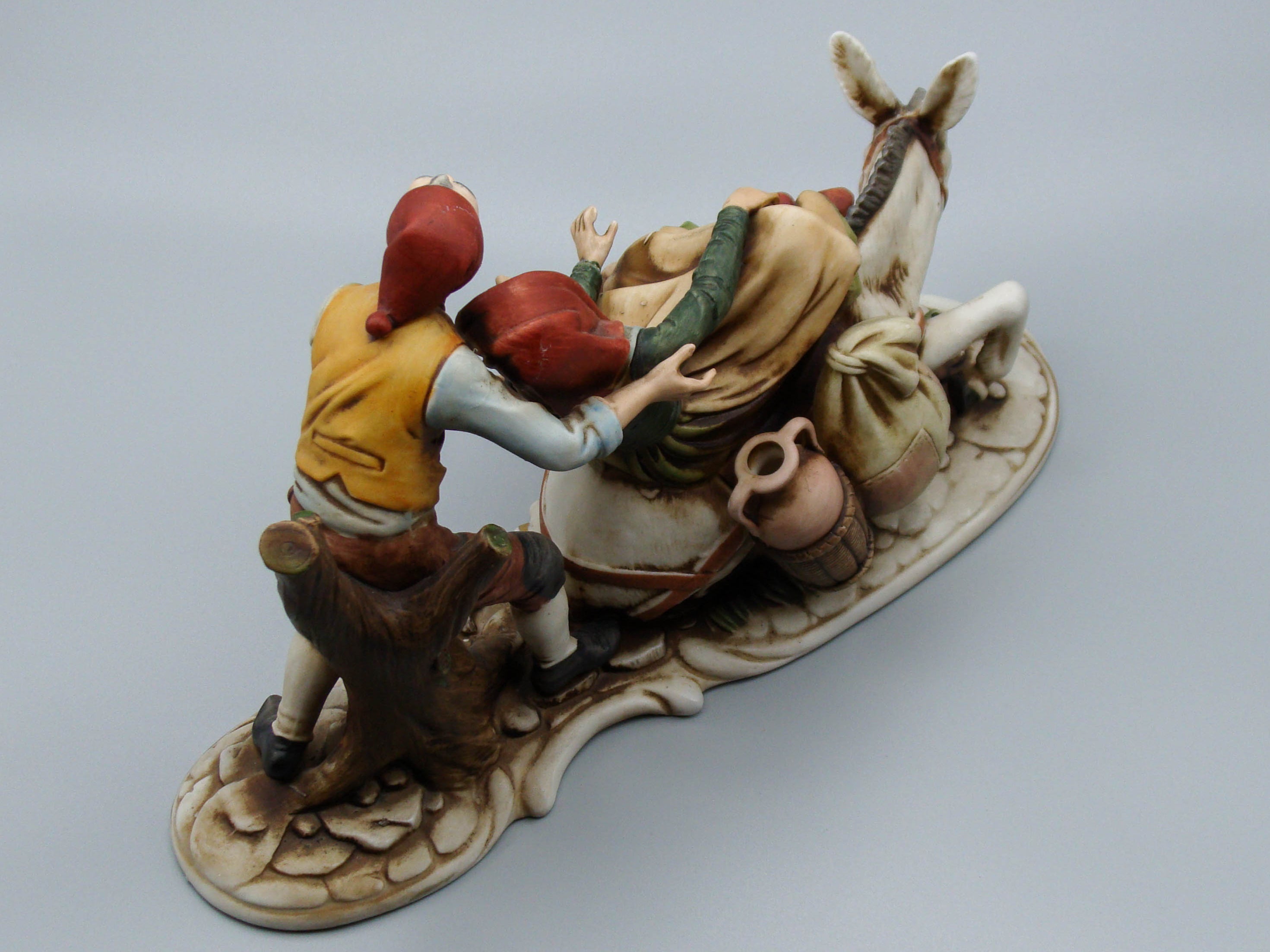Merchant pair with donkey porcelain figurine