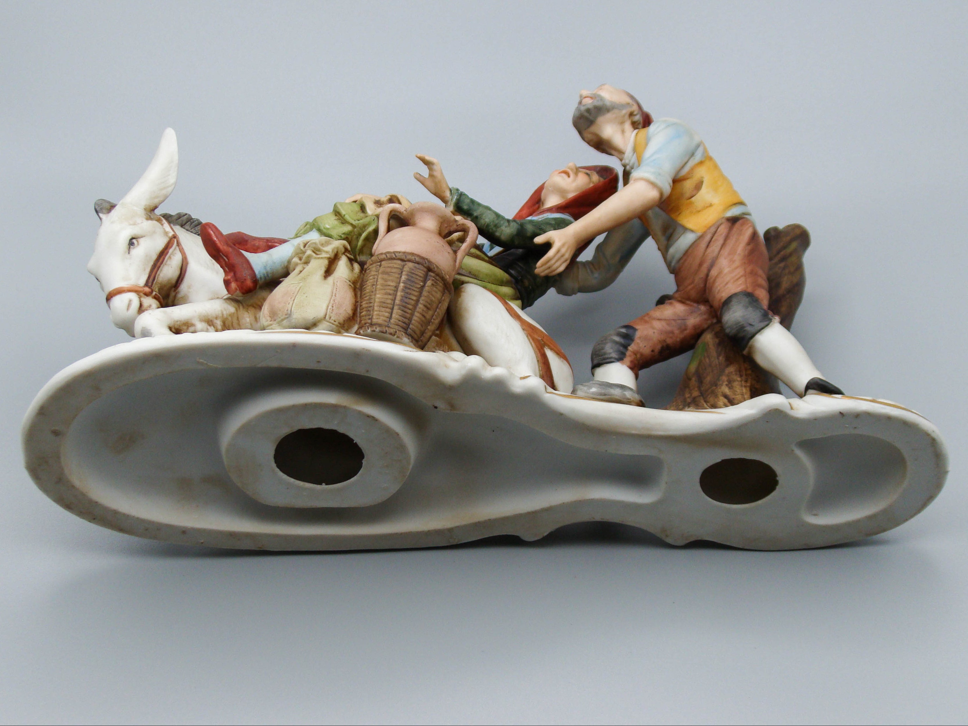 Merchant pair with donkey porcelain figurine